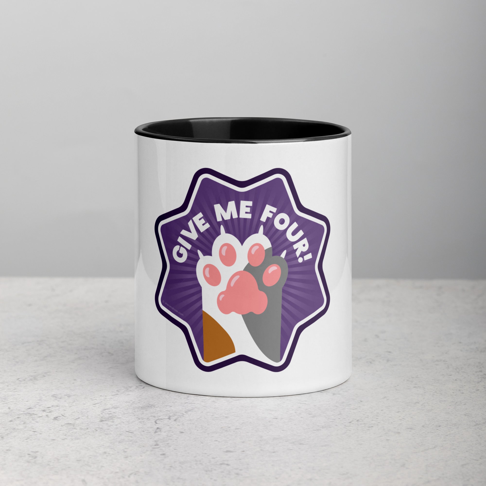 front facing image of a white mug with black interior and handle. Mug has image of a calico cats paw on a purple 8 sided star with the text 'give me four' 